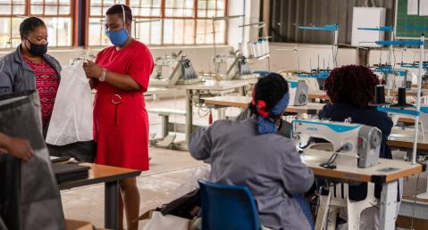 people wearing masks in a textile factory inspect product