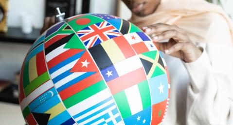 adelphi theme diplomacy, woman searching country on globe