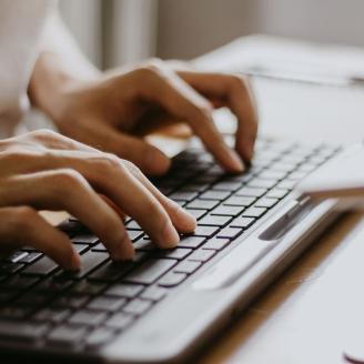 Contact us Hände, die etwas auf ein Keyboard tippen