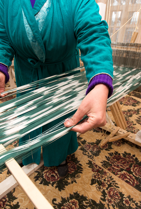 Hands of a weaver working on manual weaving loom & making Ikat