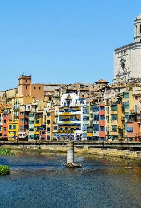 Stadt im Sonnenschein. Dichte, bunte H&auml;userblocks entlang eines Flusses. 