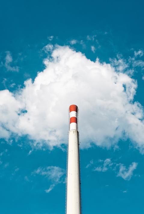 Three narrow chimneys against blue sky. 