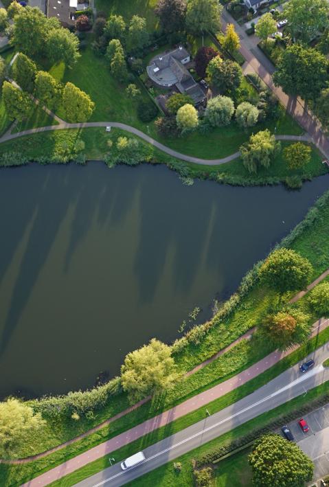 Ein Gew&auml;sser entlang einer Stra&szlig;enfahrbahn mit Kreisverkehr
