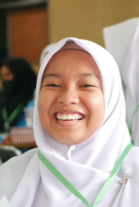 Indonesian school girl smiles into the camera. 