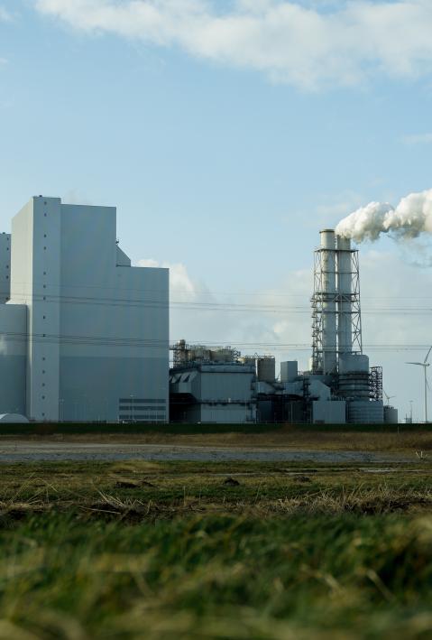 Eine Industrieanalage mit rauchenden Schornsteinen und T&uuml;rmen.