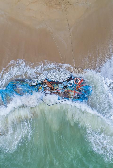 fisher boat and nets washed up on beach