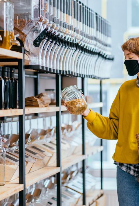 person with mask grabs a glass in a zero waste shop
