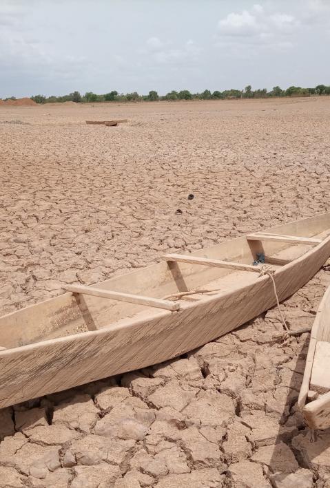 Zwei Holzboote liegen in einem getrocknetes Flussbeet.