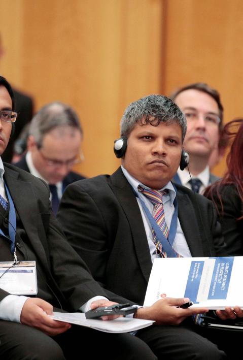 Teilnehmende einer Konferenz sitzen im Saal und h&ouml;ren einer Rede zu