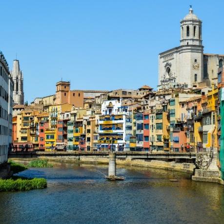 Stadt im Sonnenschein. Dichte, bunte H&auml;userblocks entlang eines Flusses. 