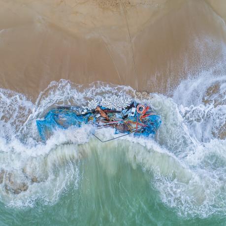 fisher boat and nets washed up on beach