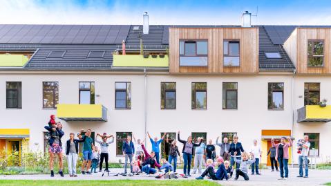 Menschen stehen vor dem Wohnprojekt der Energiegenossenschaft Ilmtal eG