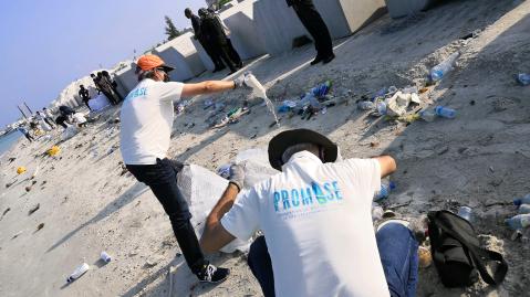 Gruppe reinigt Strand von Plastik.