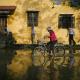 &Uuml;berflutete Stra&szlig;e durch die eine Person mit dem Fahrrad f&auml;hrt. 